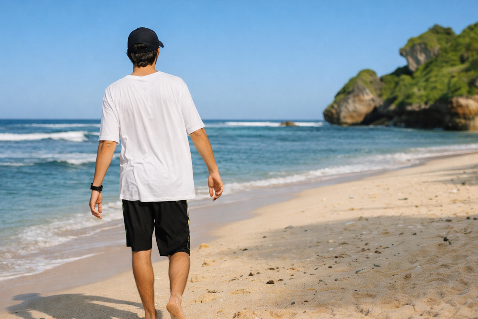Hombre caminando por la playa tras un injerto capilar en verano evitando exposición solar directa